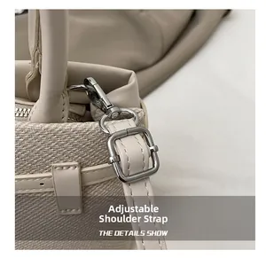 Detail of adjustable leather strap with silver metal hooks on woven tote bag