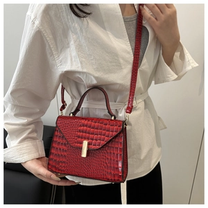 Détail du sac en cuir motif crocodile rouge foncé avec boucle en métal doré