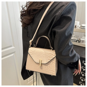 Détail du sac beige motif crocodile avec fermoir rotatif minimaliste en métal doré