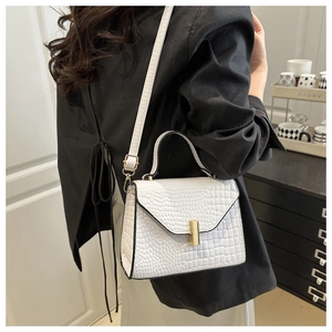 Détail du sac à bandoulière blanc motif crocodile avec boucle dorée et poignée ronde