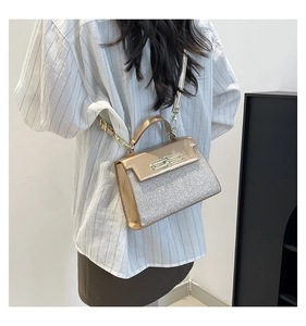 Detail view of champagne gold sequin handbag featuring a minimalist metal buckle and strap