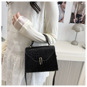 Détails du sac à main texture lézard avec boucle dorée et bandoulière en cuir