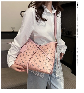 Close-up of pink tote bag with bear pattern and textured leather hanging tag detail