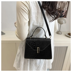 Vue latérale du sac à main noir motif crocodile avec texture et détails de boucle dorée