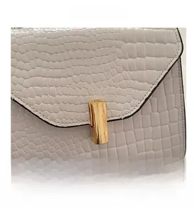 Détail de la texture crocodile blanc et du fermoir rectangulaire en métal doré chic