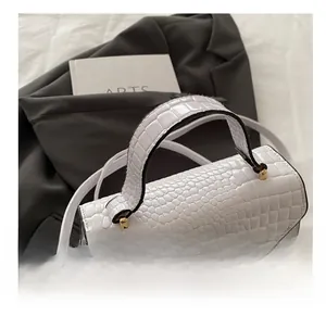 Détails de la texture crocodile blanche et du fermoir rotatif doré sur le sac à main