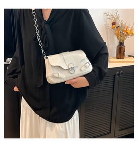 Détail du sac à main en cuir blanc crème avec fermoir rotatif argenté et chaîne