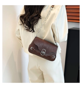 Gros plan sur un sac moto marron foncé vintage avec boucle argentée et bandoulière