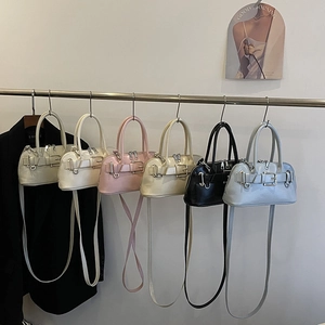Retro shell bowling bag with belt buckle details in multiple colors and shoulder strap