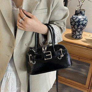 Retro black shell handbag with silver buckle and top handles shown in a lifestyle setting