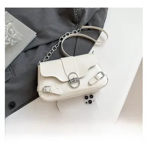 Détail du sac baguette vintage crème avec boucle argentée et smartphone pour taille