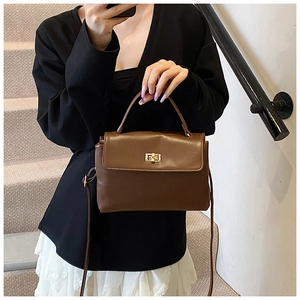 Brown soft leather crossbody bag shown on model with gold vintage buckle details