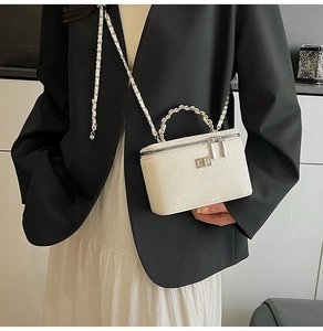 Detailed view of white snake skin texture vanity bag with silver chain and metal handle