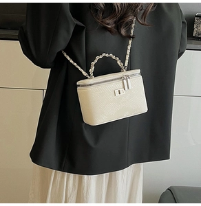 Rear view of a white snake pattern mini box bag with silver chain strap on a model
