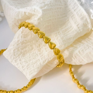 Detailed close-up of 18K gold plated chain bracelet featuring interlocking solid heart links