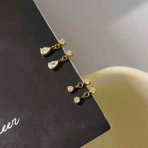 Vue détaillée des boucles d'oreilles goutte en zircon avec placage or et fleurs blanches