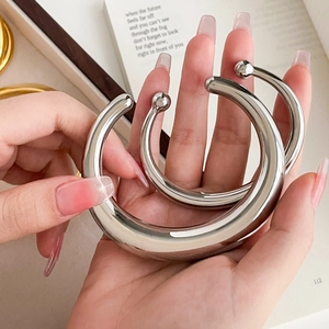 Macro view of silver chunky teardrop bangles with polished finish and ball ends