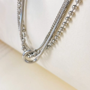 Macro shot of a triple-layered silver punk necklace with snake, link and bead chains