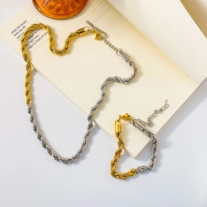 Detail of two-tone gold and silver rope chain jewelry set on vintage book pages