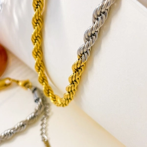 Macro detail of two-tone gold and silver rope chain with sturdy lobster clasp link
