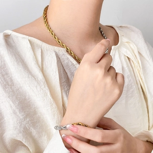 Detail of two-tone gold and silver rope chain necklace and bracelet in punk style