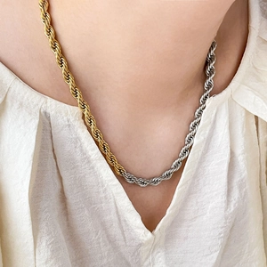 Macro detail of two-tone braided rope chain necklace in 18K gold and silver steel finish