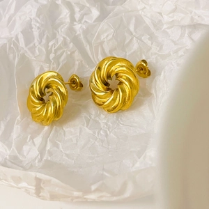 Detailed macro view of 18K gold plated chunky twisted spiral stud earrings with wave edges