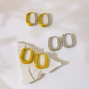 Close-up of three pairs of oval hoop earrings in gold, silver, and two-tone high polish steel