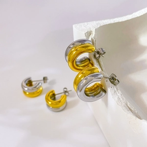Detailed view of two-tone C-shape steel hoop earrings with high-polished mirror finish