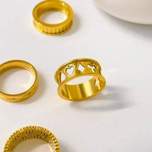 Detail of 18K gold-plated titanium steel rings featuring hollow poker suits and textures