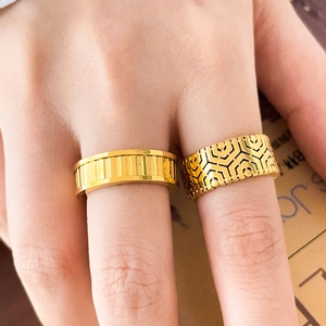 Detail view of 18K gold-plated titanium rings with honeycomb and striped textured engraving