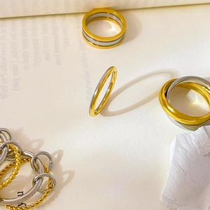 Artistic layout of multi-layered gold and silver titanium steel rings with twisted textures
