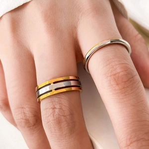 Detailed macro view of stacked tri-color gold and silver stainless steel layered rings