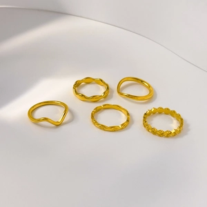 5-piece set of wave and textured 18K gold plated titanium steel rings on white backdrop
