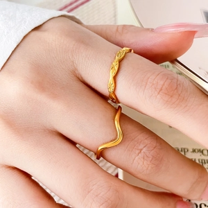 Detailed view of 18K gold plated wavy rings and starburst engravings on model's hand