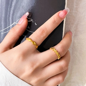 Macro detail of wave-shaped 18K gold-plated stainless steel ring with textured finish