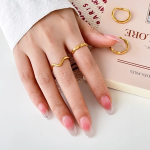 Detail of 18K gold-plated titanium steel rings with wave pattern and woven texture