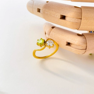 Detail of 18K gold-plated bypass ring with green and white round-cut zircon stones