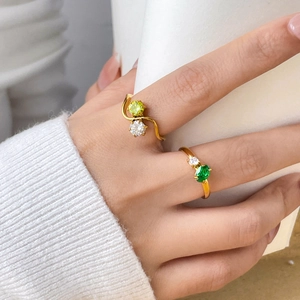 Detail of 18K gold plated titanium rings with double green and white zircon stones