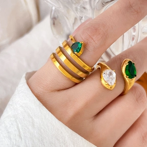 Detailed view of 18K gold-plated snake-style rings with green and white pear-cut zircon stones