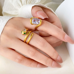 Snake head spiral gold ring with green zircon eyes and purple gemstone centerpiece
