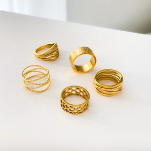 Set of five gold textured rings including honeycomb, hammered, and layered designs