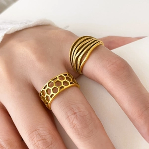 Detailed view of wide gold titanium rings featuring honeycomb hollow and multilayered lines