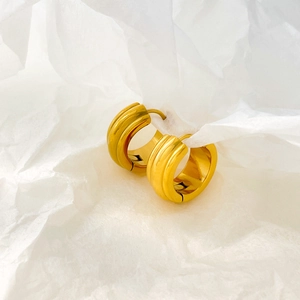Macro view of gold hoop earrings featuring a unique three-arc pumpkin textured design