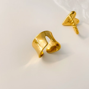 Close-up of golden irregular wavy ring and beaded heart ring with high mirror polish