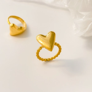 Detailed view of gold-plated heart rings with beaded and polished band designs