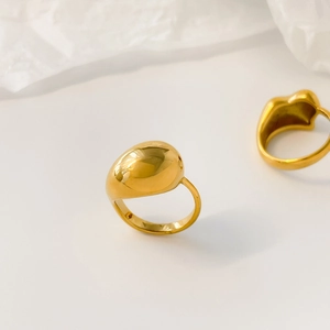 Detailed view of wide concave heart-shaped liquid gold ring with reflective finish