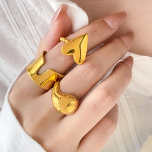 Three-piece gold plated ring set featuring heart, wavy wide, and smooth teardrop designs