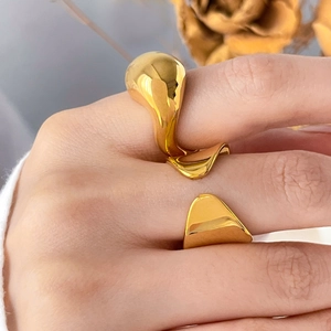 Close-up of a wide polished gold irregular heart-shaped ring in organic curved design