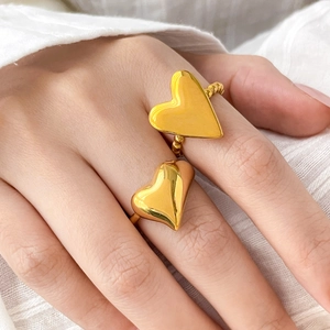 Golden heart rings set with beaded and smooth bands on a minimalist background